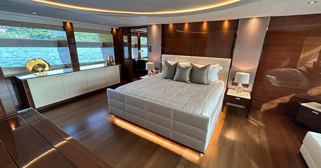 Master cabin onboard charter yacht LE VERSEAU, central berth facing forward with large windows to port