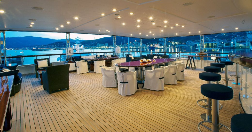 tables set for alfresco dining on upper deck aft of superyacht ‘Force Blue’ 