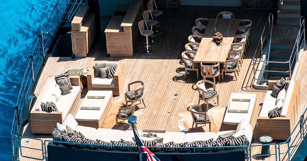 bar, seating areas and dining table on aft deck of luxury yacht ‘Plan B’