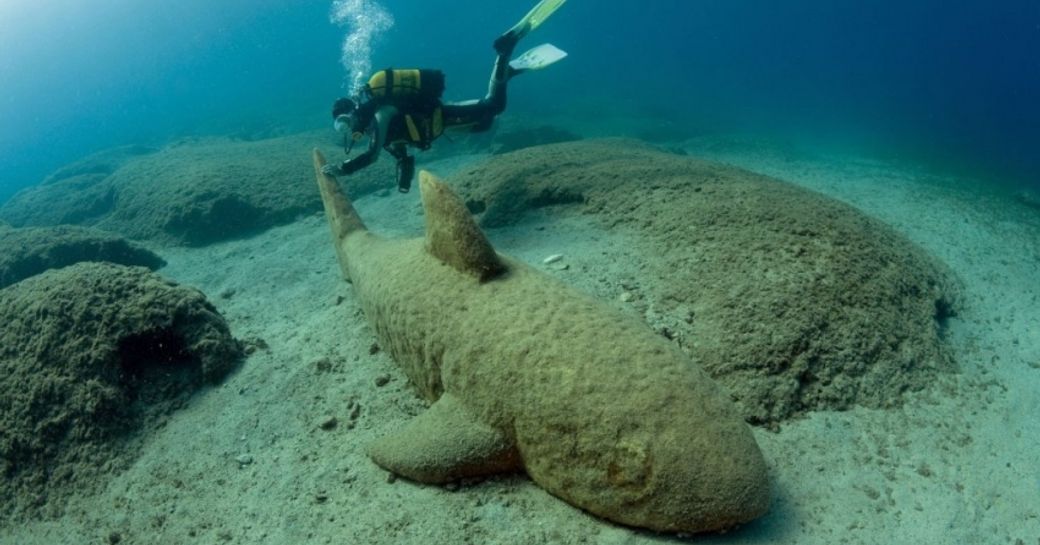 A diver inspects a shark hewn out of a rock in Kas, Turkey
