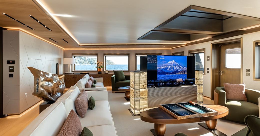 Overview of interiors onboard charter yacht LA DATCHA, with an extensive lounge area and large TV