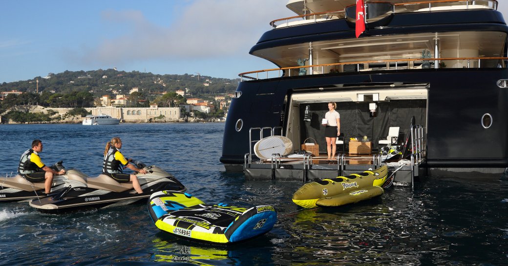 Benetti's motor yacht BASH's swim platform and beach club with her guests cruising on the onboard water toys