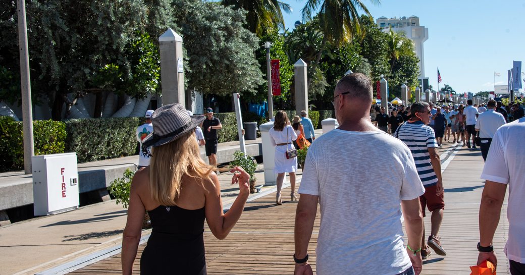 Visitors at FLIBS walking along the docks in discussion with each other.