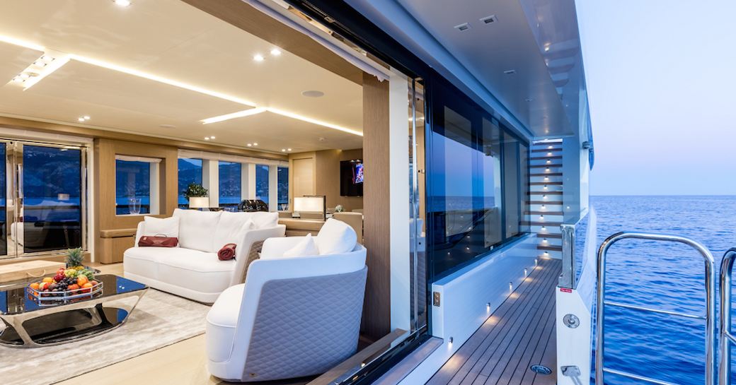 full-length window in main salon of charter yacht K opens up onto drop-down side balcony 