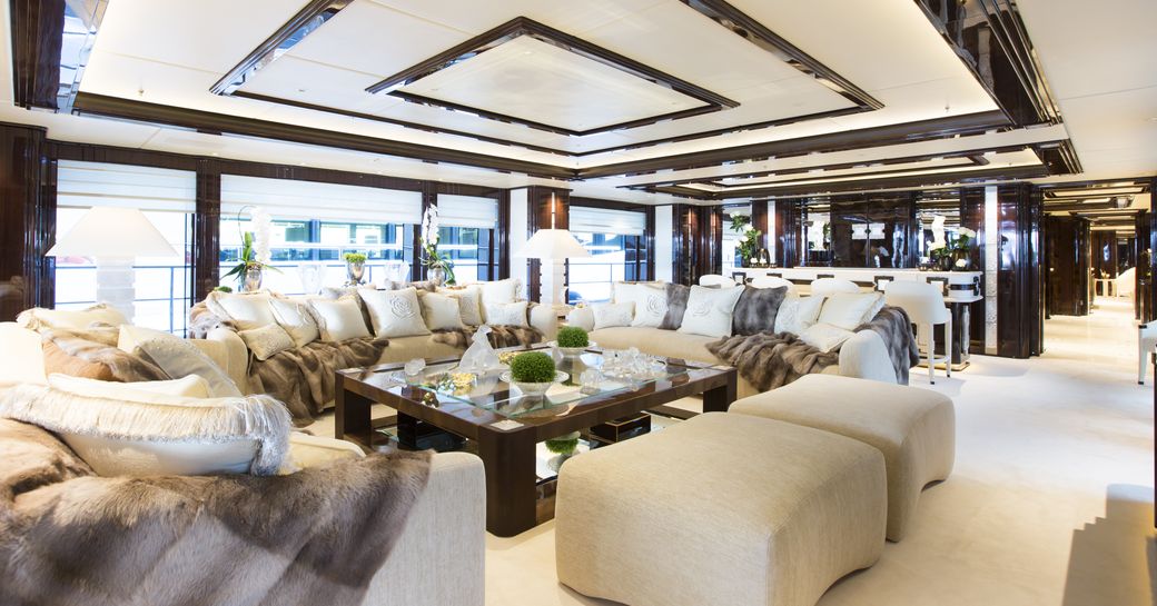 Main salon onboard charter yacht ILLUSION V, plus lounge area surrounded by full-length windows