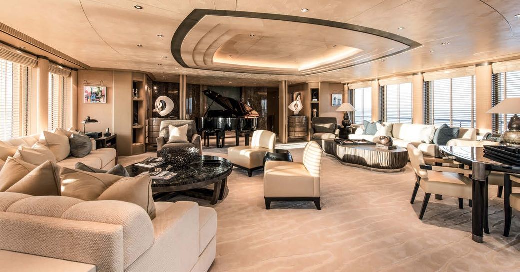 salon with multiple seating arrangements and grand piano aboard superyacht RoMEA 
