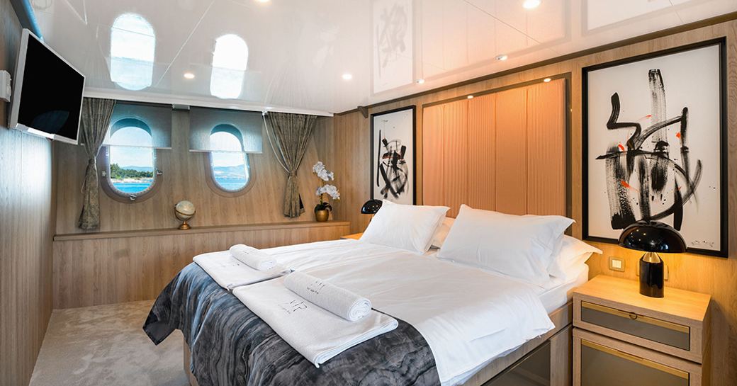 Master cabin onboard charter yacht AGAPE ROSE, central berth facing starboard with two small windows in the background
