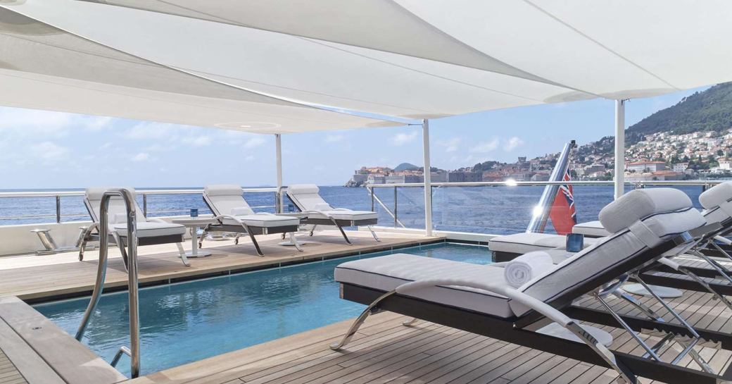 pool with loungers and optional shade on board motor yacht AQUARIUS 