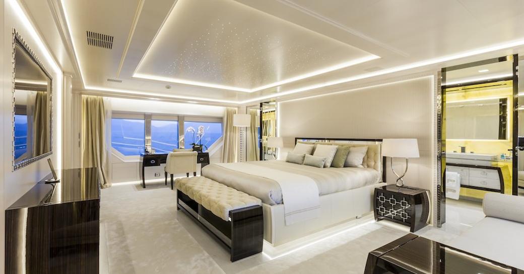 Master cabin onboard charter yacht PARILLION, central berth with seating and large window in background