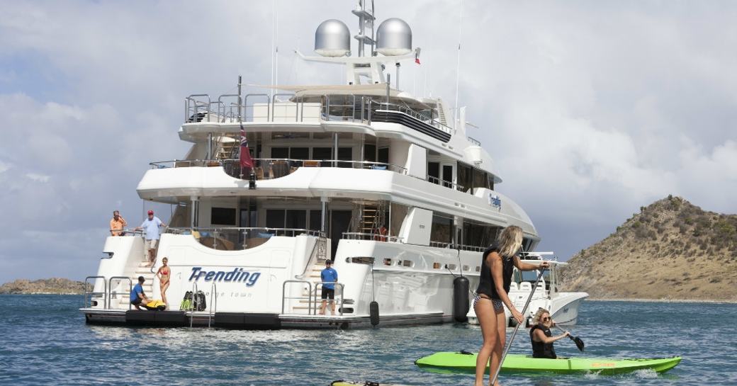 charter guests play on the stand-up paddle boards as superyacht TRENDING anchors nearby