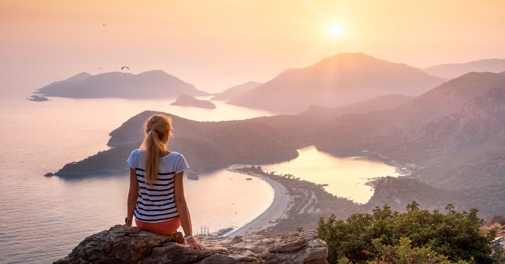 A girl looks out over the islands of Fethiye in Turkey at sunset
