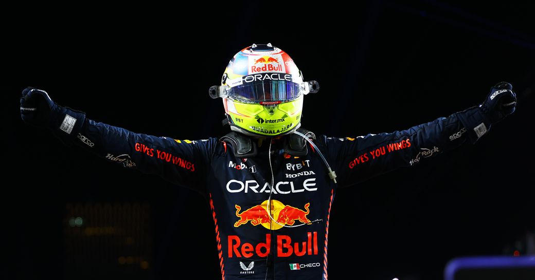 A Formula One driver celebrating against a dark sky
