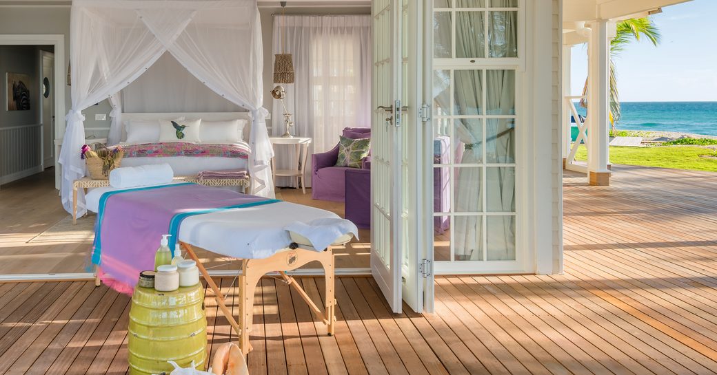 villa suite on thanda island, with doors to the terrace open and massage table set up