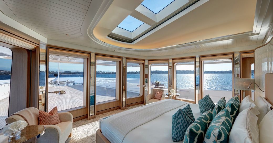 owner's suite on board feadship charter yacht joy, with skylight in ceiling and panoramic windows looking over foredeck