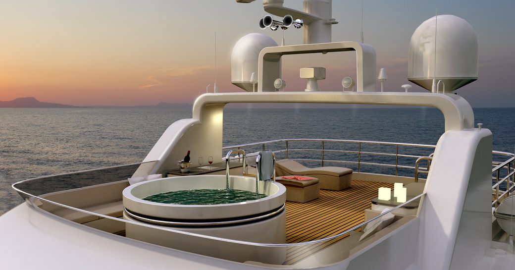 Sunset view of sundeck of luxury charter yacht Christina G, with jacuzzi pool and candles