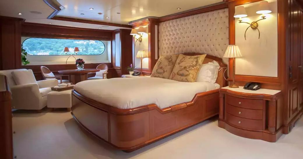 Master cabin onboard charter yacht JO I, central berth facing forward with large glazing in the background 