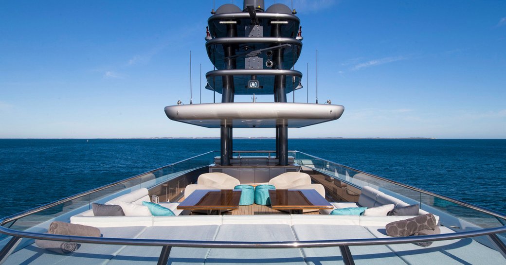 Colorful furnishings arranged around the sundeck of a superyacht, with the ocean visible in the distance
