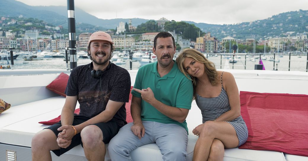 Adam Sandler, Jennifer Aniston and crew member pose on sun pads aboard motor yacht SARASTAR while filming Murder Mystery