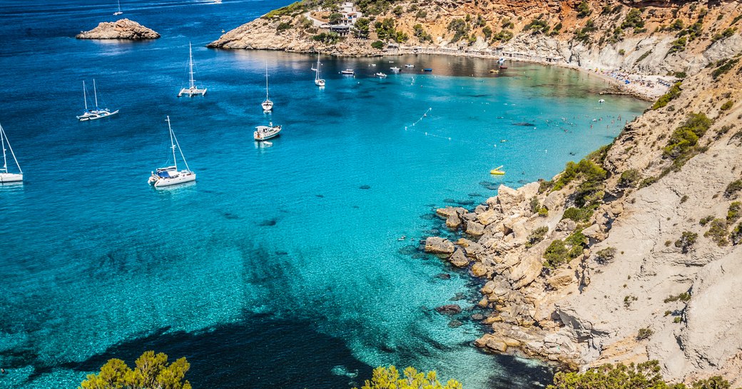 charter yachts in a secluded bay in ibiza, the balearic islands