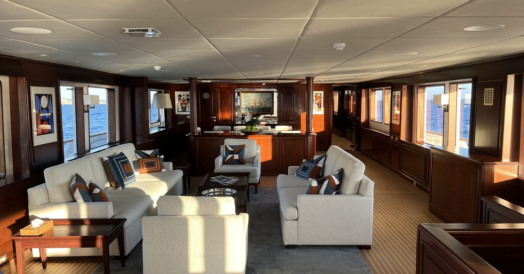 Main salon onboard charter yacht GENESIA, spacious lounge forward with windows on either side