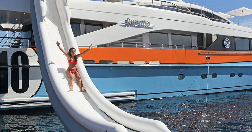 Woman going down water slide on a yacht