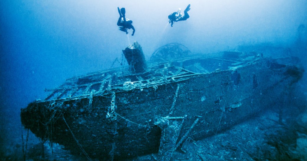 Scuba divers examine a shipwreck in Greece