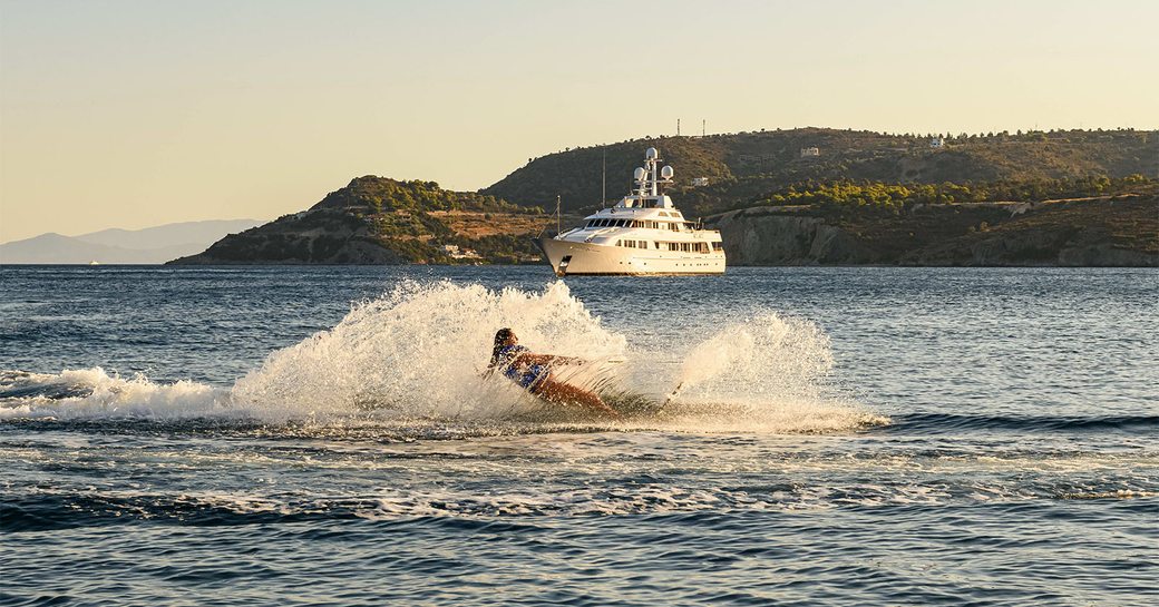 woman waterskiing in front of charter yacht