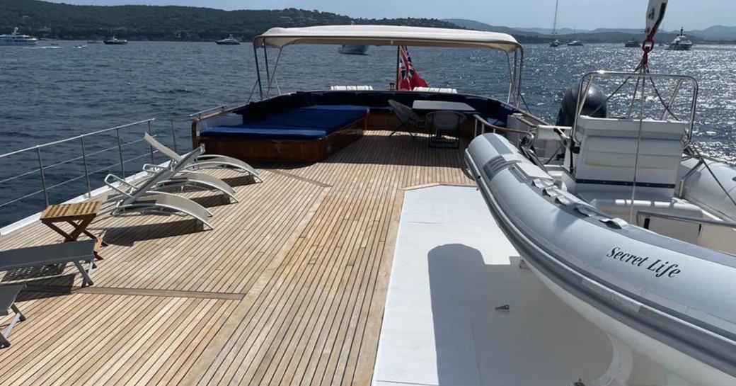 Overview of the sun deck onboard charter yacht SECRET LIFE with a tender in the foreground