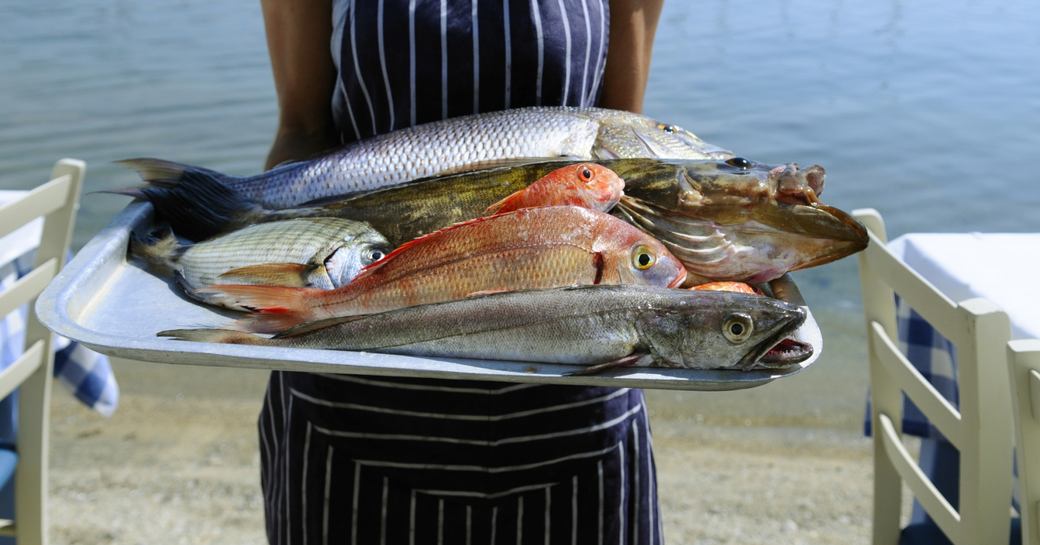Waitress displaying locally caught fish for lunch