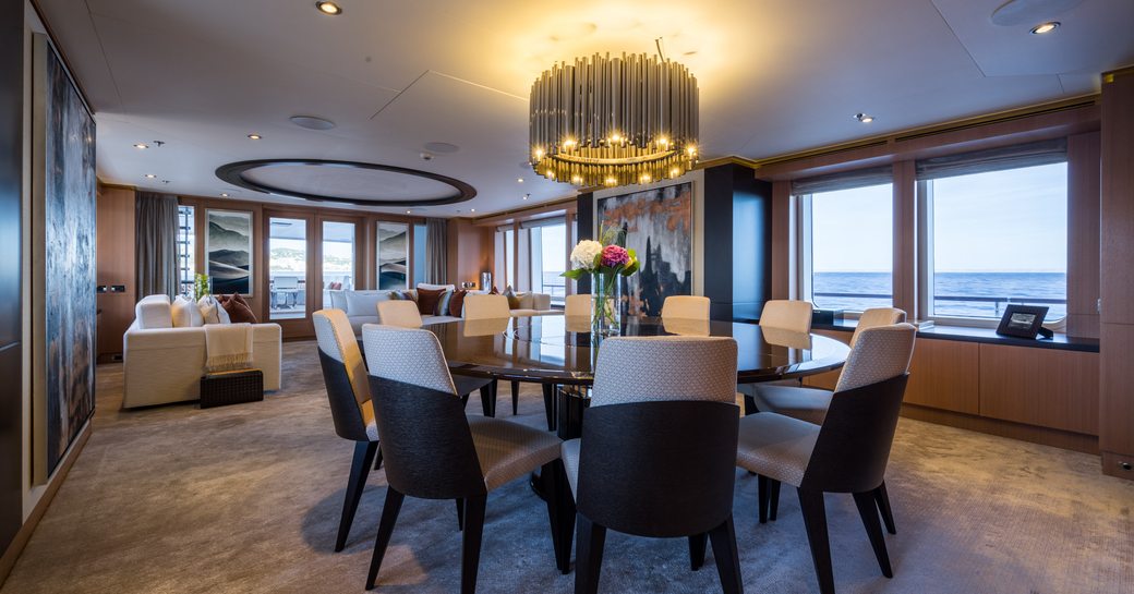 circular dining table with lounge beyond in main salon of superyacht GO