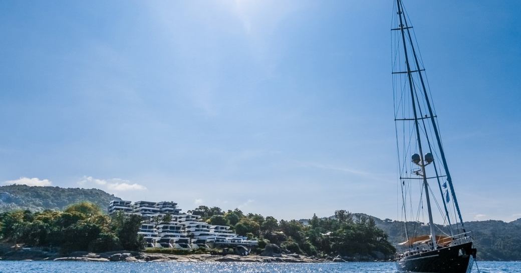A sailing yacht with the Kata Rocks resort in the distance