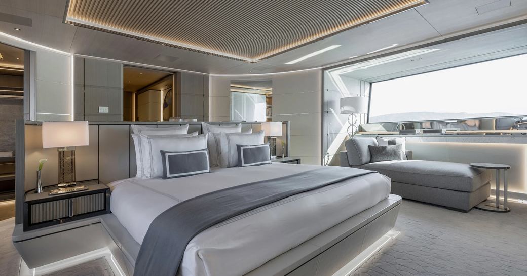 Overview of the master cabin onboard charter yacht ALCHEMY, central berth with wide window in the background