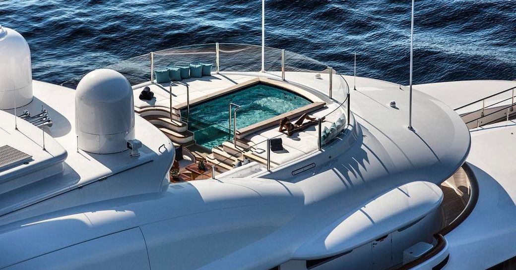 aerial view of woman on luxury charter yacht aquila's sun deck next to jacuzzi pool