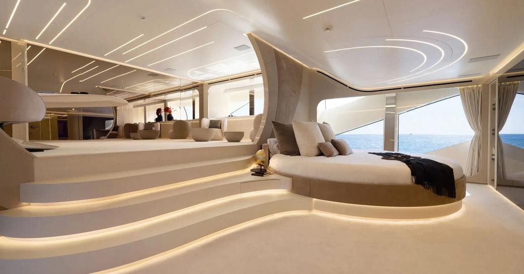 Master cabin onboard charter yacht N1, circular berth forward with steps leading up to private lounge 