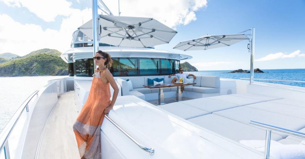 charter guest poses by the foredeck seating and sunning area on board motor yacht ‘King Baby’ 
