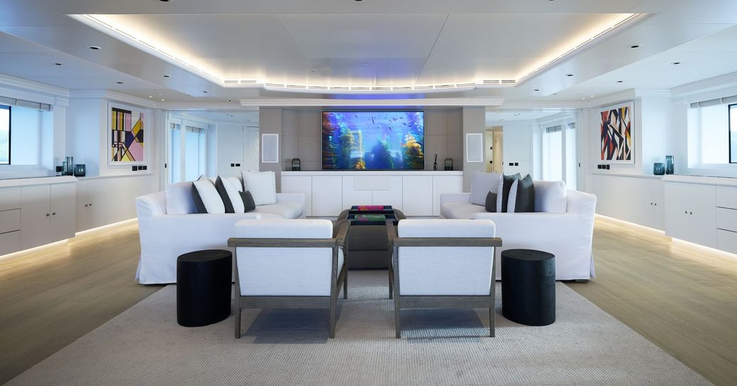 Overview of the main salon onboard charter yacht ARBEMA, spacious lounge area with white sofas facing in 