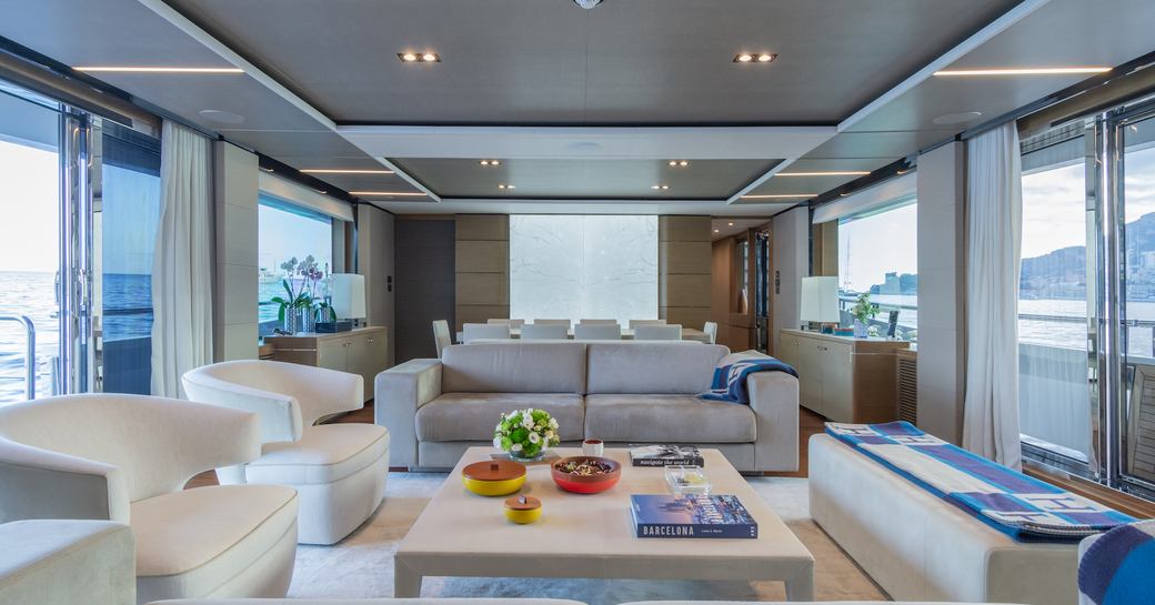 Overview of the main salon onboard charter yacht MInor Family Affair, with lounge area in the foreground and dining area aft