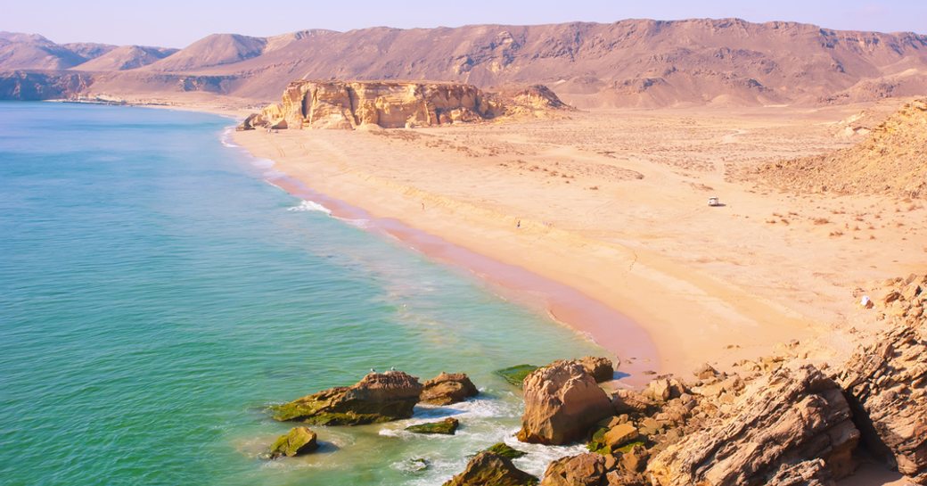 sandy beach and mountain backdrop in oman