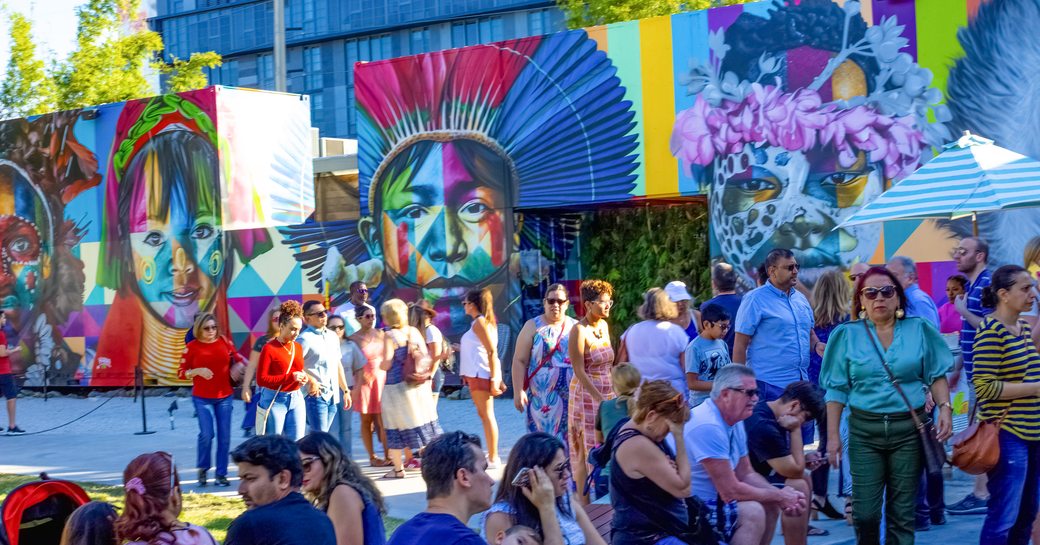 A mural on the streets of Miami as part of the Art Basel Miami exhibit, with tourists walking by