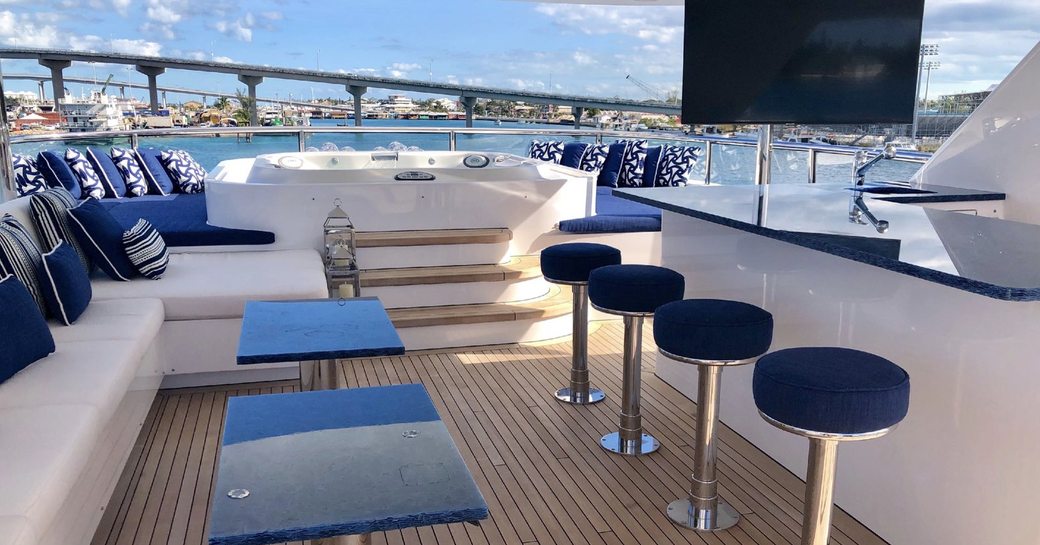 seating, bar, TV and spa pool on the sundeck of motor yacht TANZANITE 