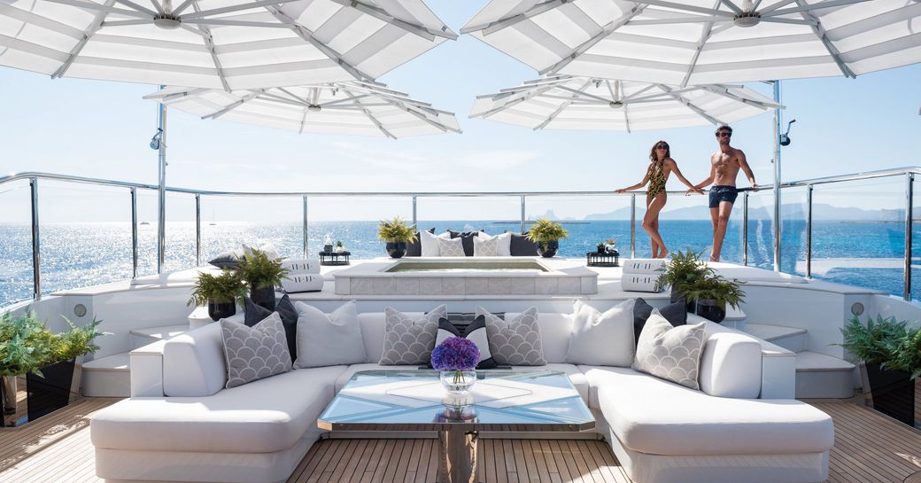 Superyacht 11/11 sundeck, with charter guests relaxing in the sun