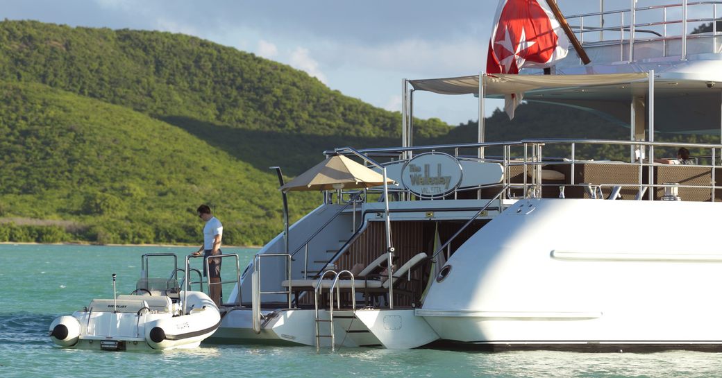 the swim platform of the wellesley with the crew of below deck Mediterranean preparing the tender for the guests on a luxury yacht charter vacation in mallorca 