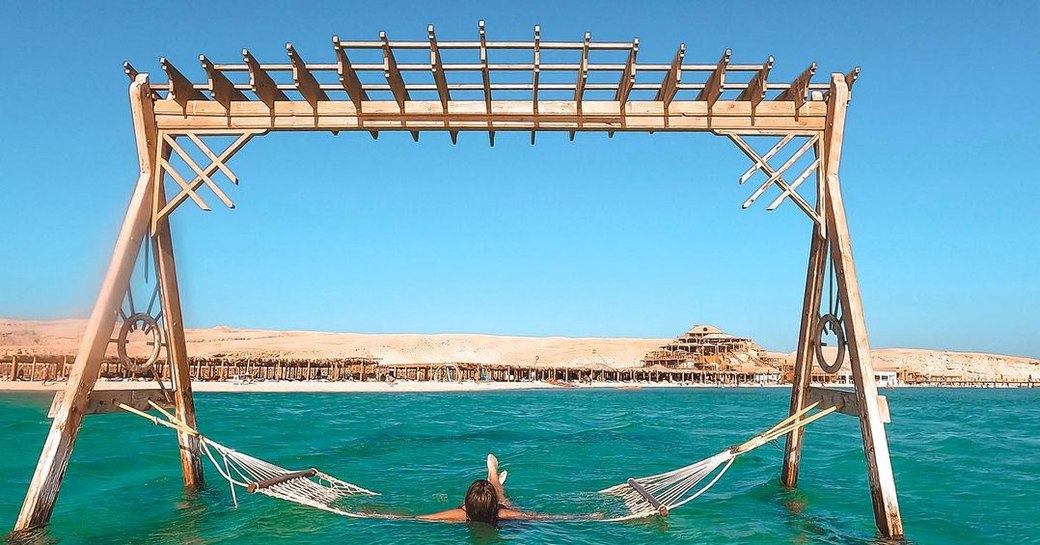 woman reclining on a hammock in the water