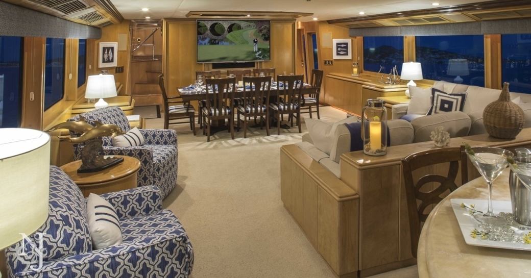 lounge area and dining table in main salon of luxury yacht ‘Kelly Anne’ 