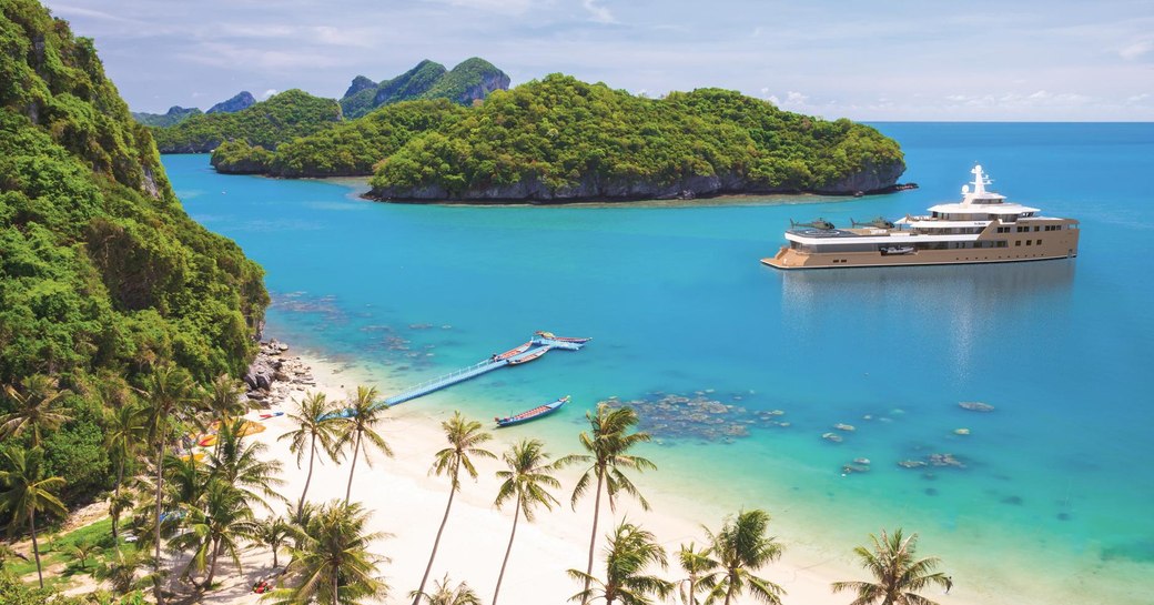 Charter yacht LA DATCHA at anchor in a bay by a paradisiac island