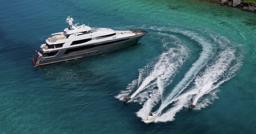 superyacht Muchos Mas at anchor as water toys take to the waters during a yacht charter