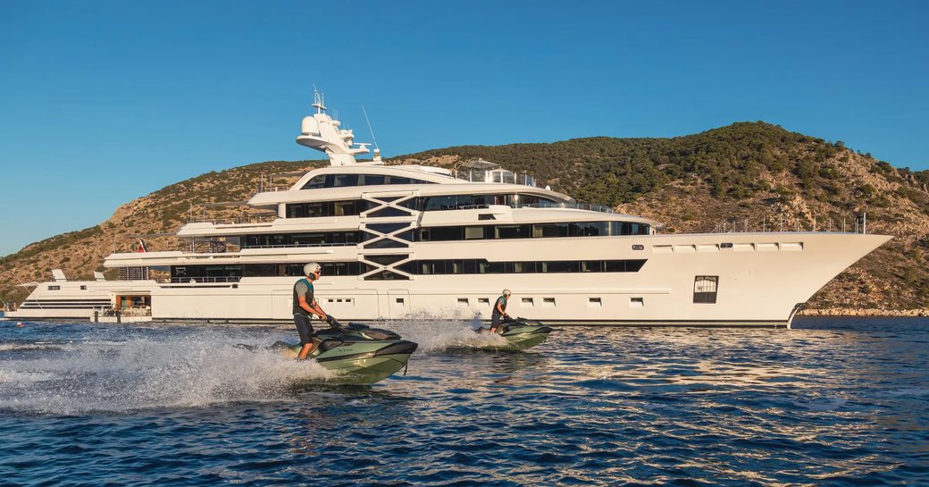 Charter yacht PROJECT X and two charter guests on Jet Skis