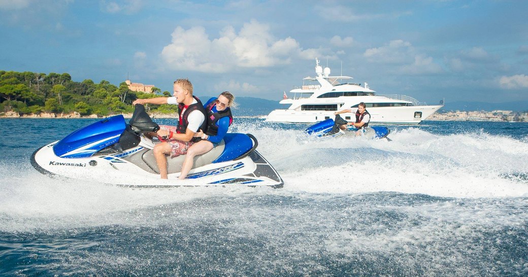 charter guests take to the jet skis as superyacht DYNAR anchors nearby