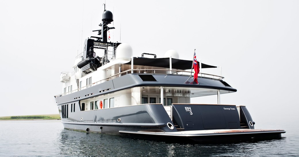 An image which shows the aft of a superyacht sat at-anchor