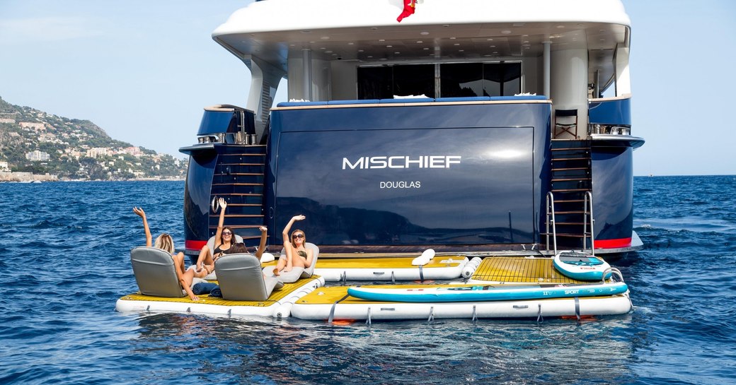 Charter guests unwind on the aft deck of superyacht MISCHIEF